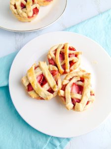 Using a 12-count muffin pan, you can create these cute and delicious mini strawberry pies! They're bursting with strawberry flavor and surrounded by a flaky all butter pie crust. These bite-sized little treats are great to share at church gatherings, birthdays, and summer BBQs. 
