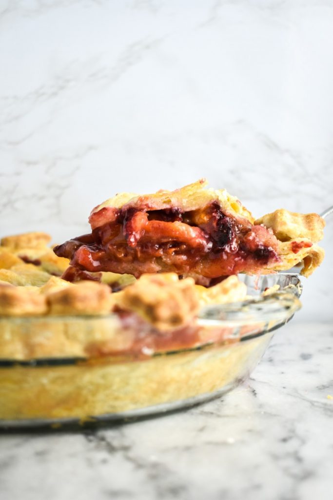 9-inch pie pan with homemade pie crust and plum filling
