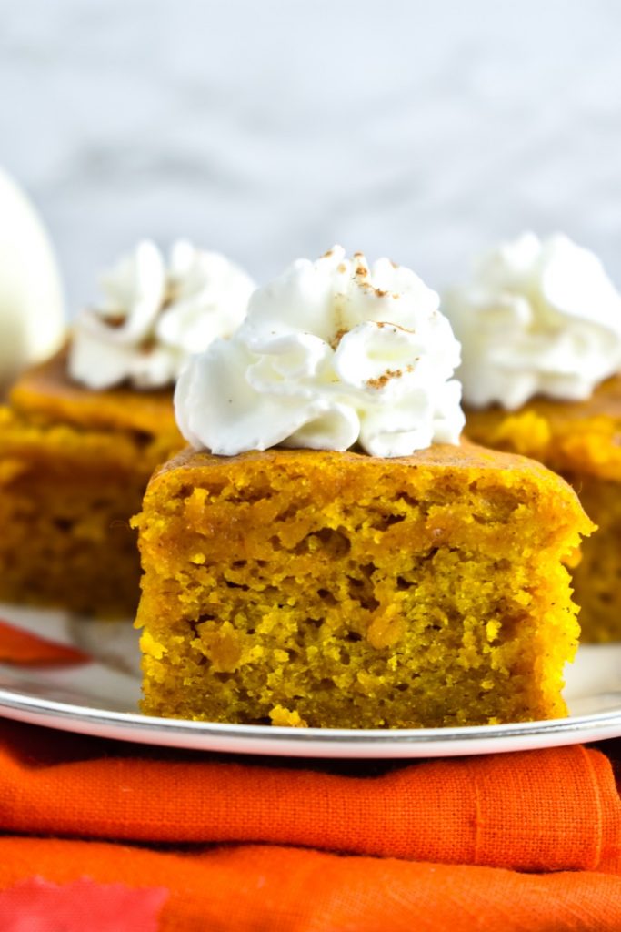 Pumpkin Spice Bars with whipped cream and cinnamon topping
