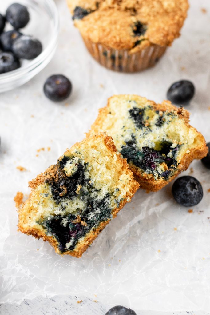 blueberry muffin cut in half full of blueberries and a moist interior