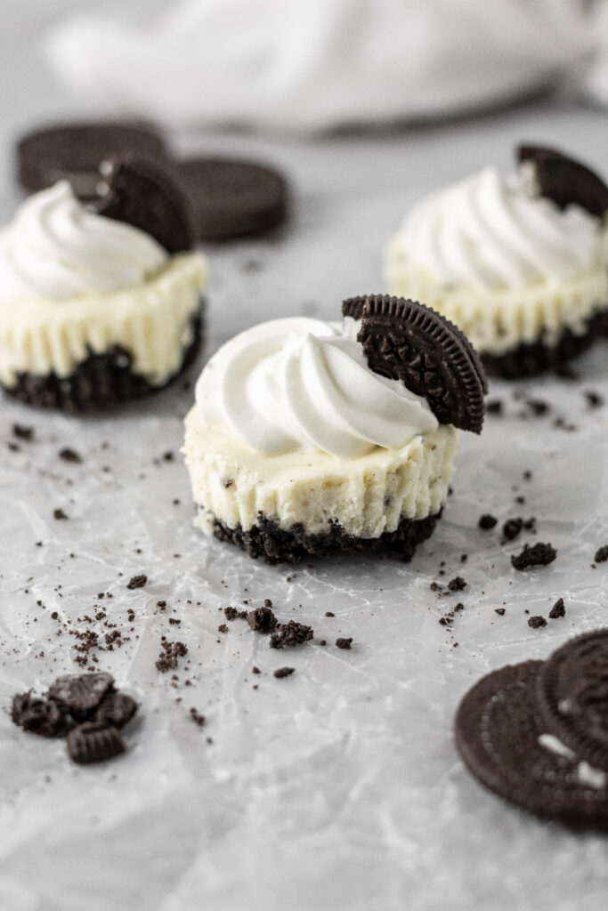 Mini oreo cheesecakes with whipped cream and oreo pieces on top