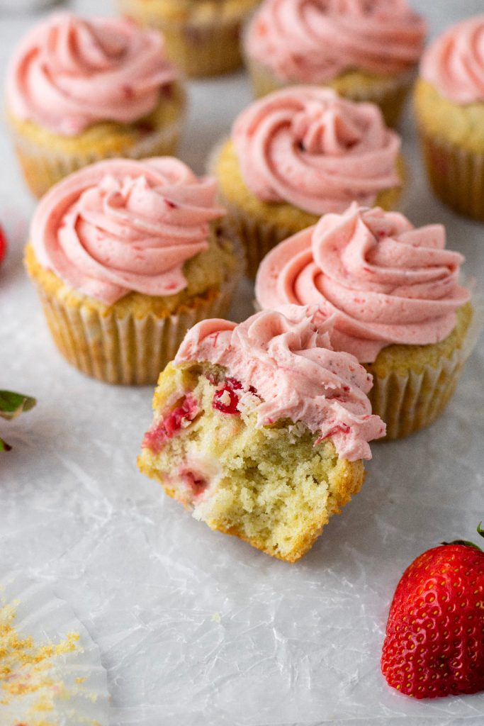 fresh strawberry cupcakes with chunks of berries in the vanilla cupcake