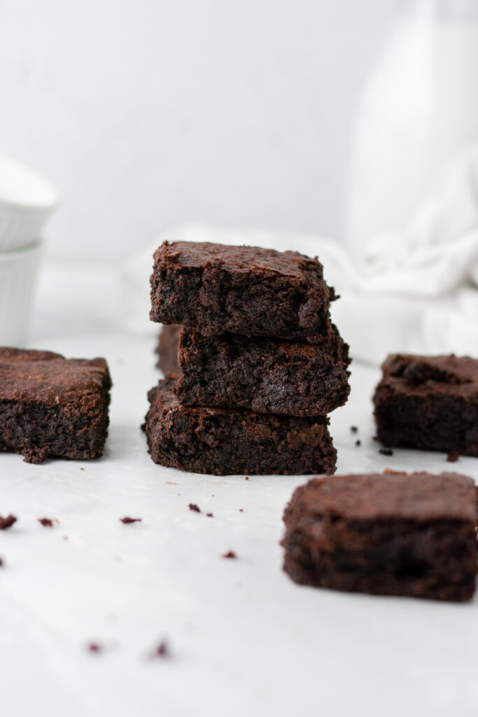 super dark chocolate brownies stacked on top of each other with super dense and chewy layers