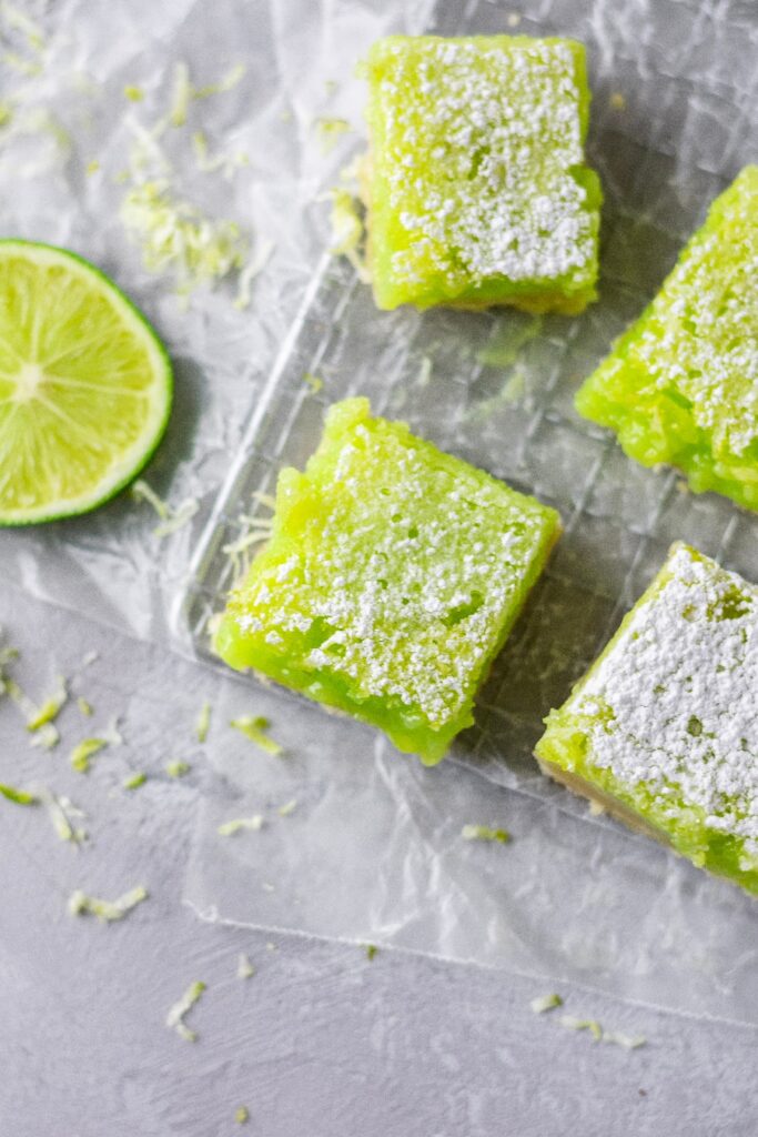 Easy lime bars recipe cut into squares and topped with powdered sugar.