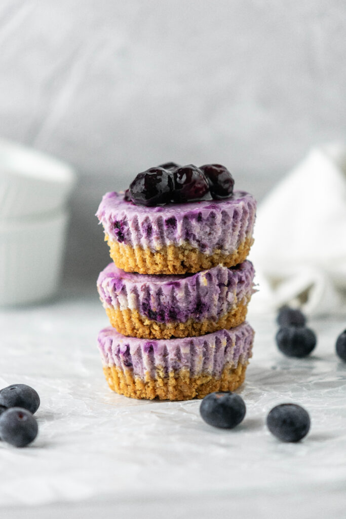 Blueberry mini cheesecakes stacked on top of eachother