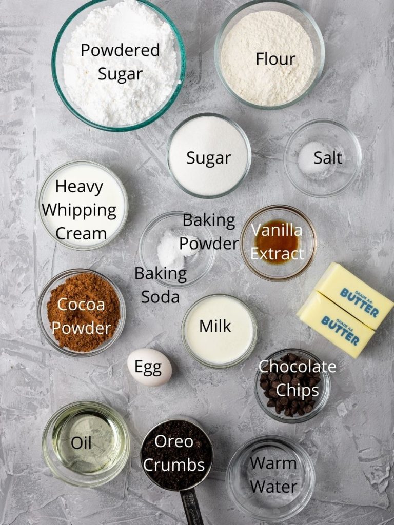 ingredients in chocolate cupcakes: powdered sugar, flour, sugar, heavy whipping cream, salt, baking powder, baking soda, vanilla extract, cocoa powder, egg, milk, chocolate chips, butter,  oil, oreo crumbs, and warm water