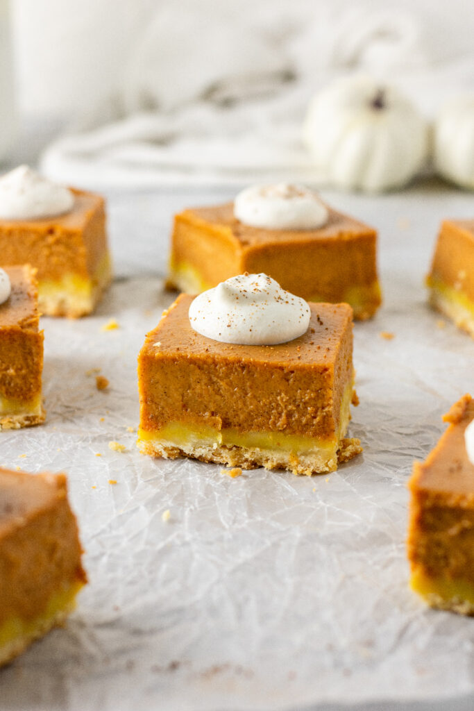 pumpkin shortbread bars topped with homemade whipped cream and nutmeg