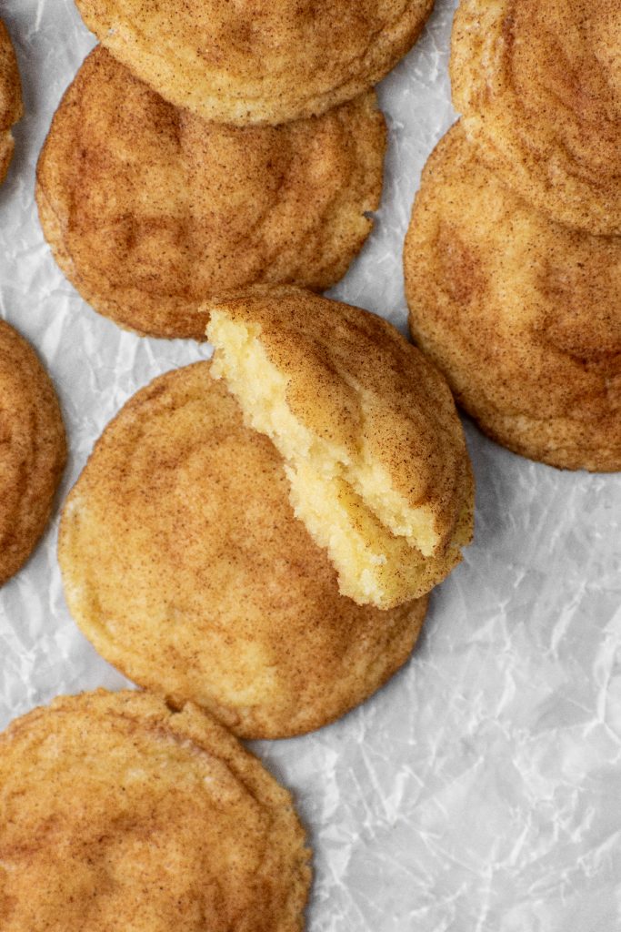 snickerdoodle cookie broken in half to see the fluffy and buttery insides