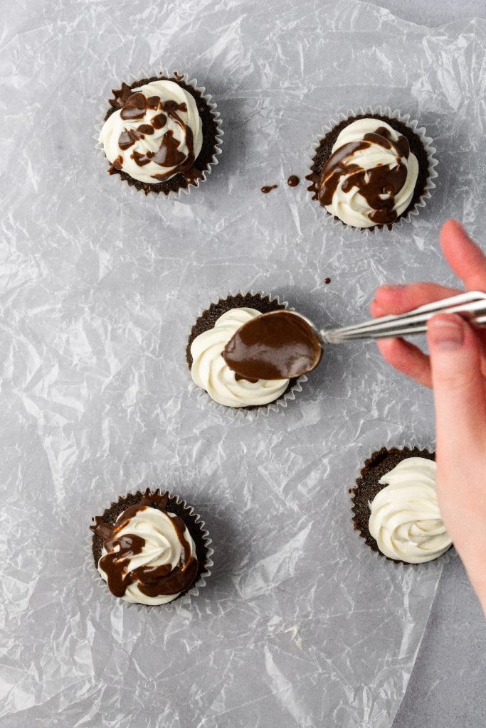 Chocolate ganache drizzle over cupcakes.