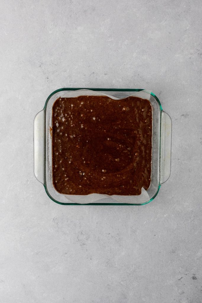 Scrape brownie batter into prepared baking pan and bake.