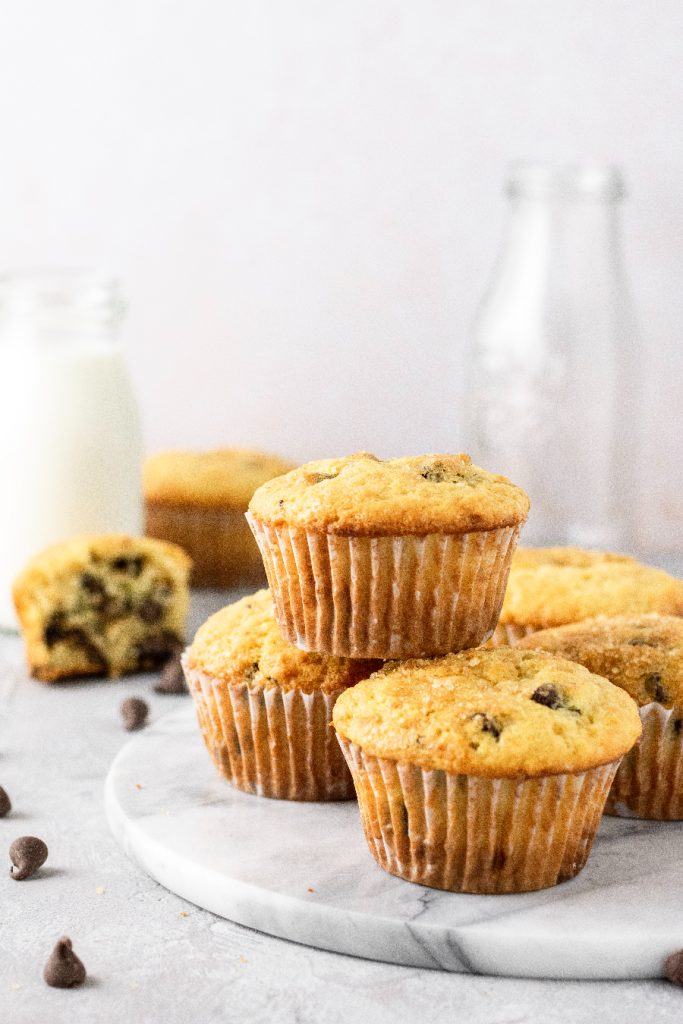 Muffins plated on a round marble plate with a jar of milk.