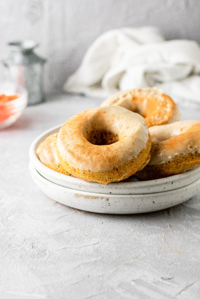 Carrot cake baked donuts on a white plate.