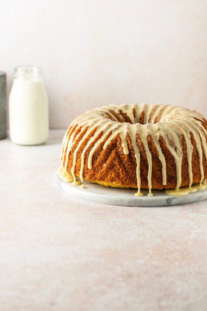 maple bundt cake with a maple glaze and milk in the background.