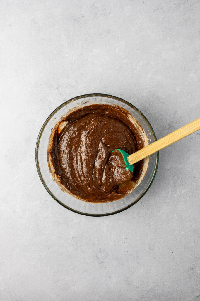 brownie batter in a bowl with a silicone spatula.