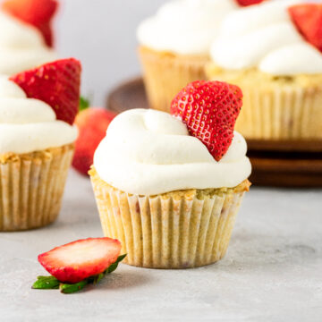 A half dozen of strawberry cupcakes with fresh whipped cream.