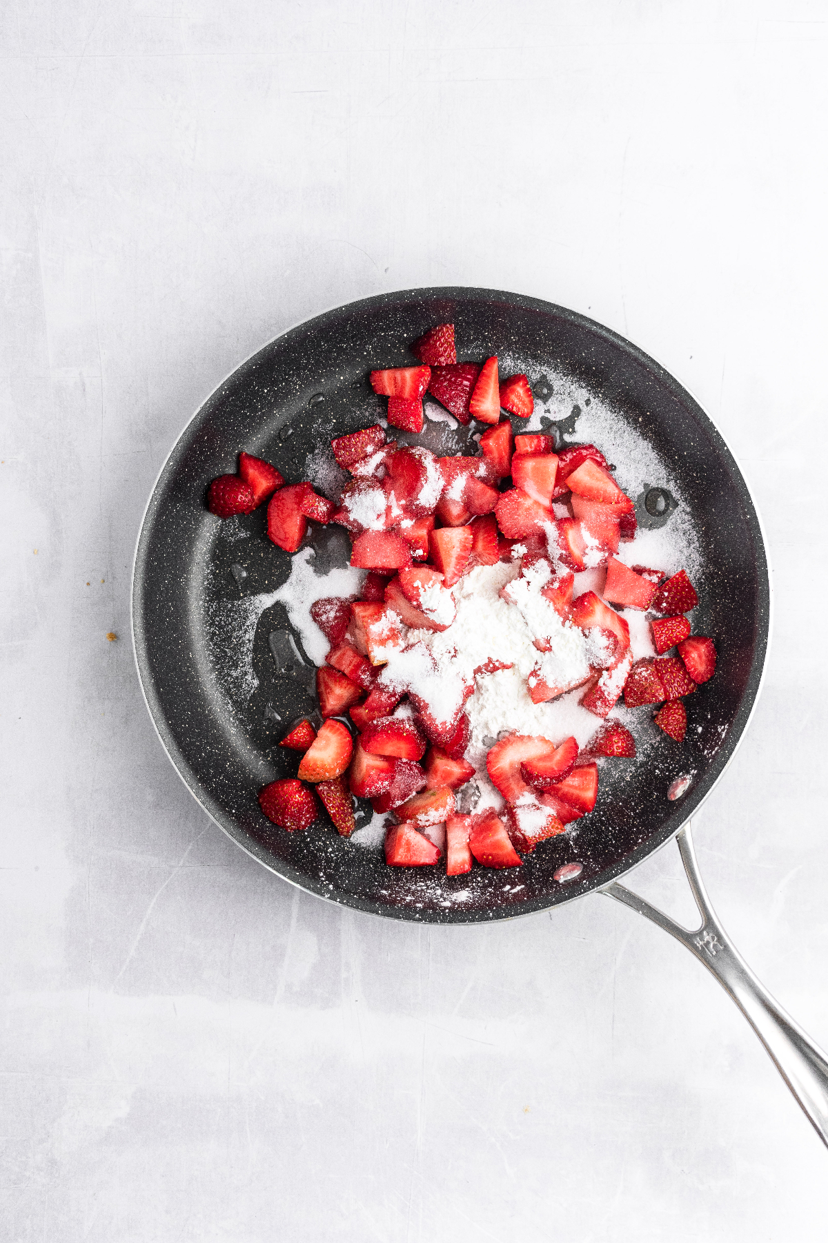 Diced strawberries and sugar in a saucepan.