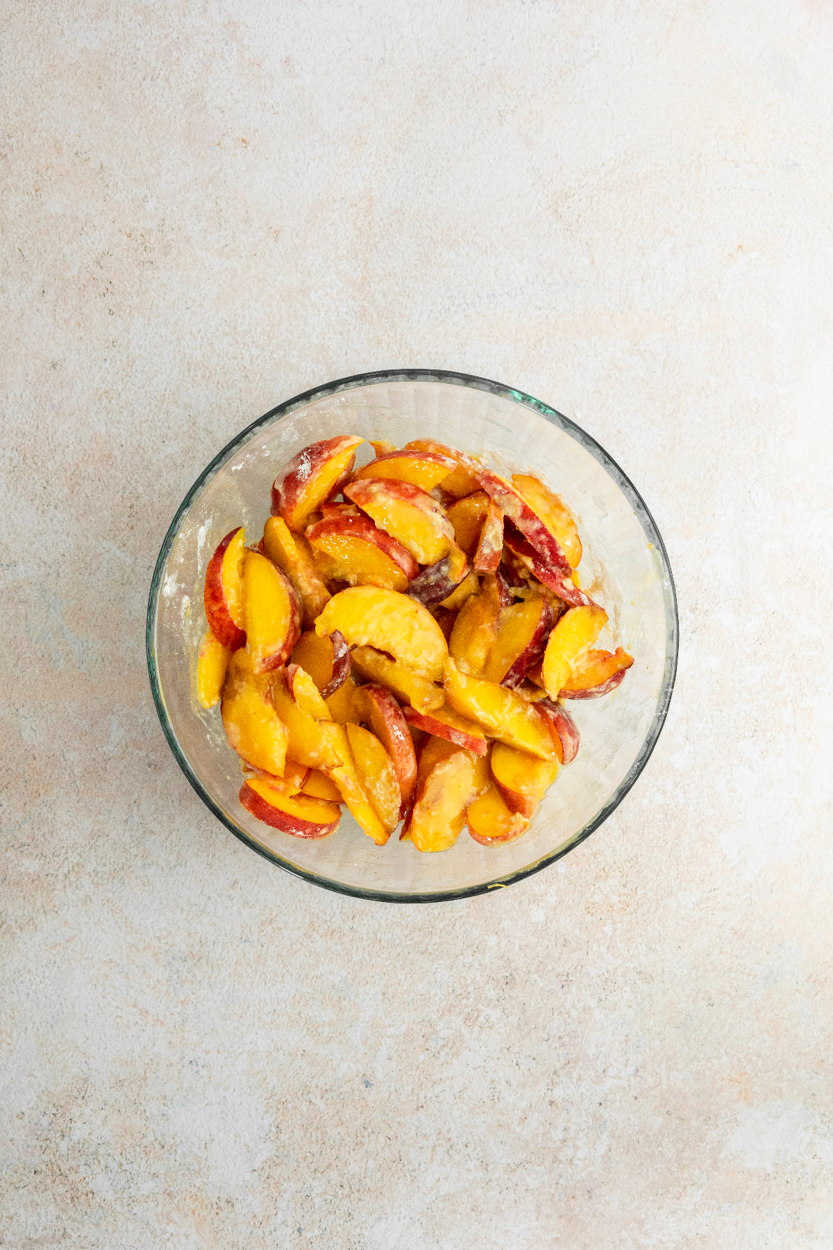 Sliced peaches in a large glass bowl.