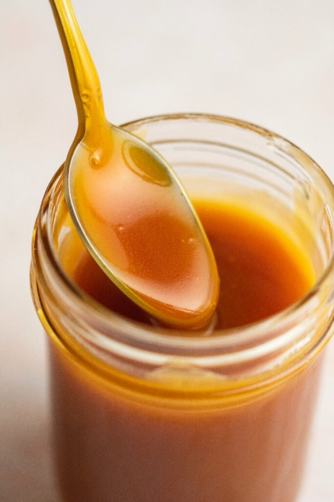 A close up view of caramel in a jar.