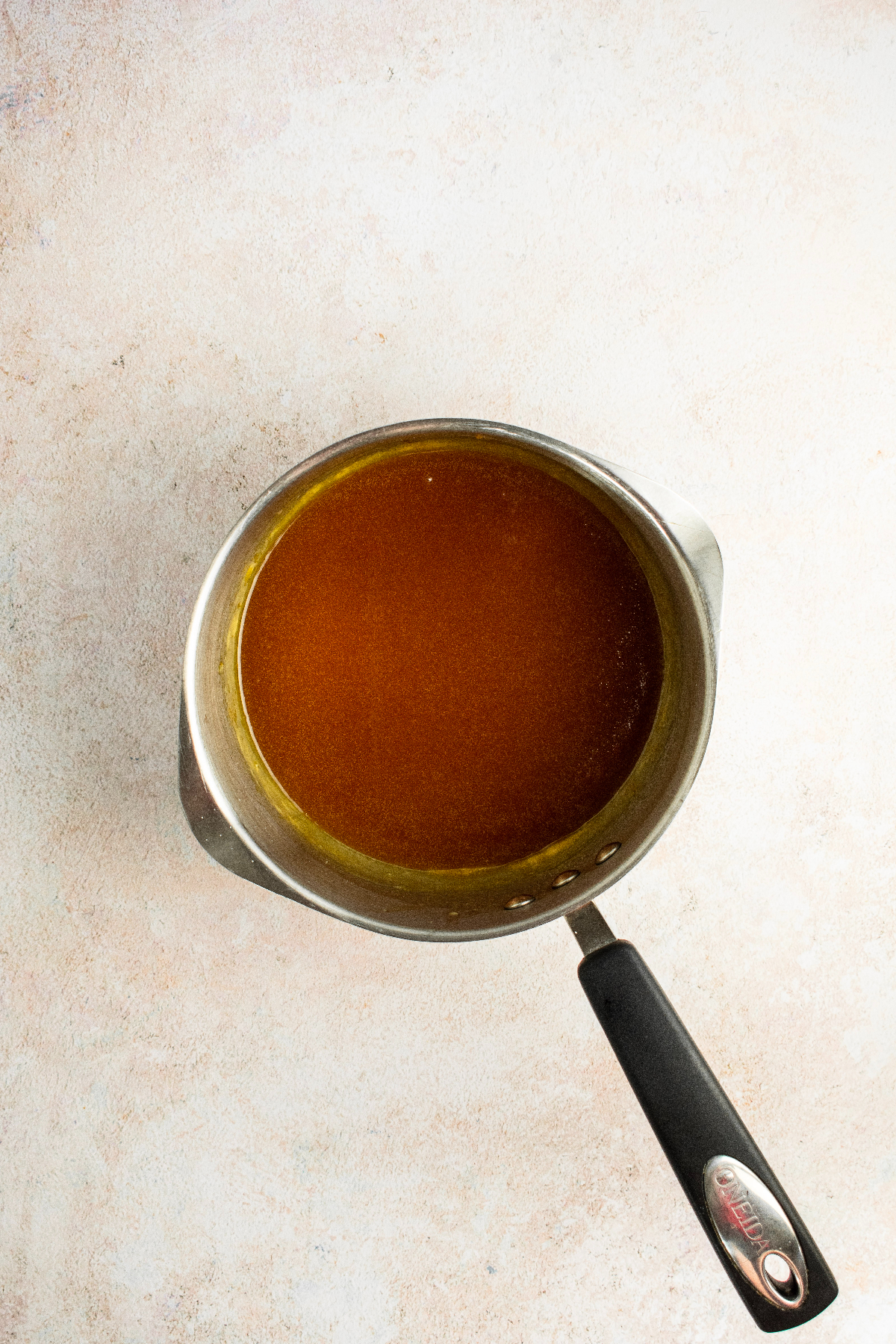 Freshly made warm caramel sauce in a metal pan.