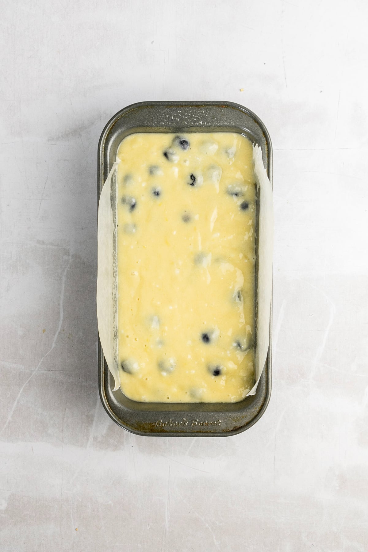 A bread pan filled with lemon blueberry batter.