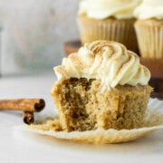 A bite taken out of a moist cupcake with cupcakes in the background on a cake stand.