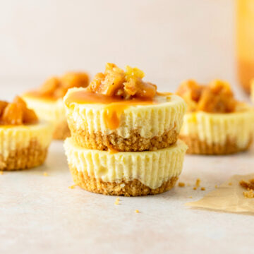 Stacked apple cheesecakes with caramel topping.