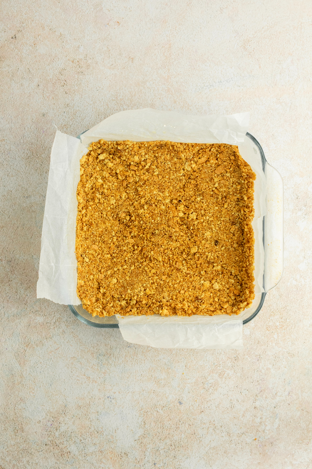 graham cracker crust in a glass baking pan.