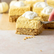 Using a fork to slice into a cheesecake bar.