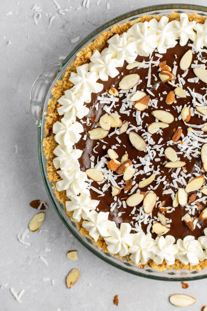 Almond joy pie with whipped cream, coconut, and almonds.
