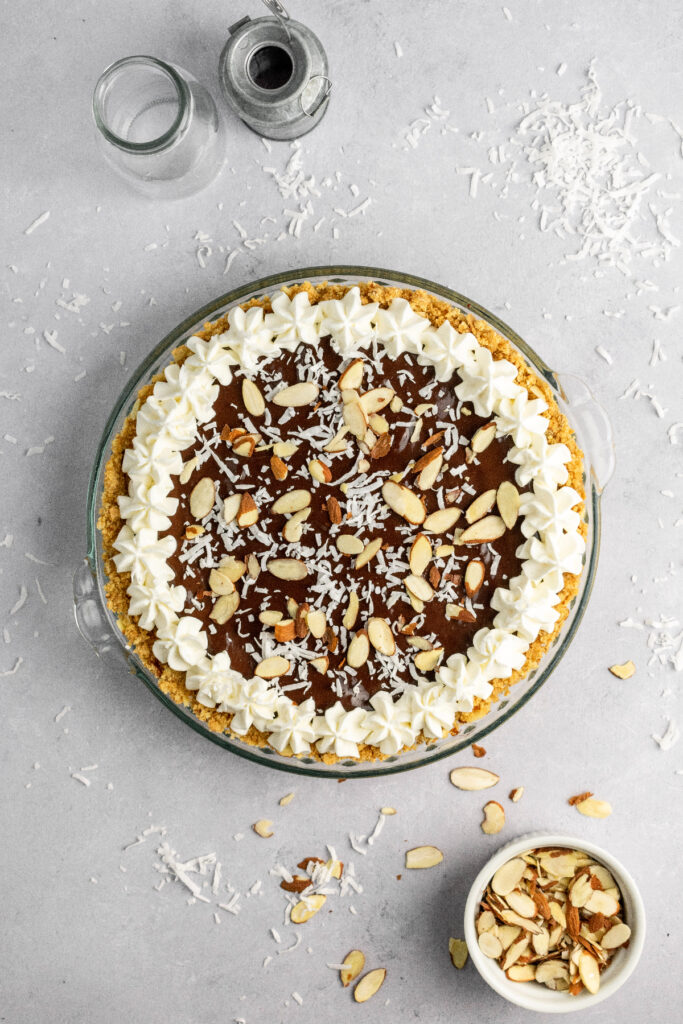 Chocolate coconut pie with coconut and almond slices on the side.