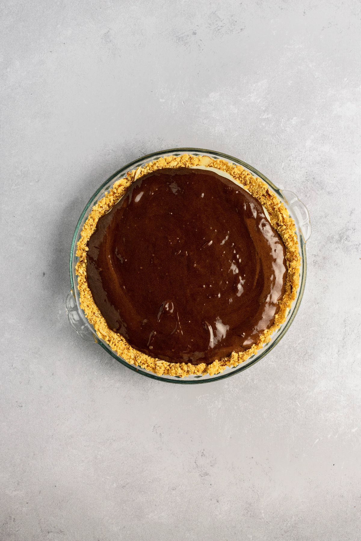 Chocolate ganache on top of a coconut pie.