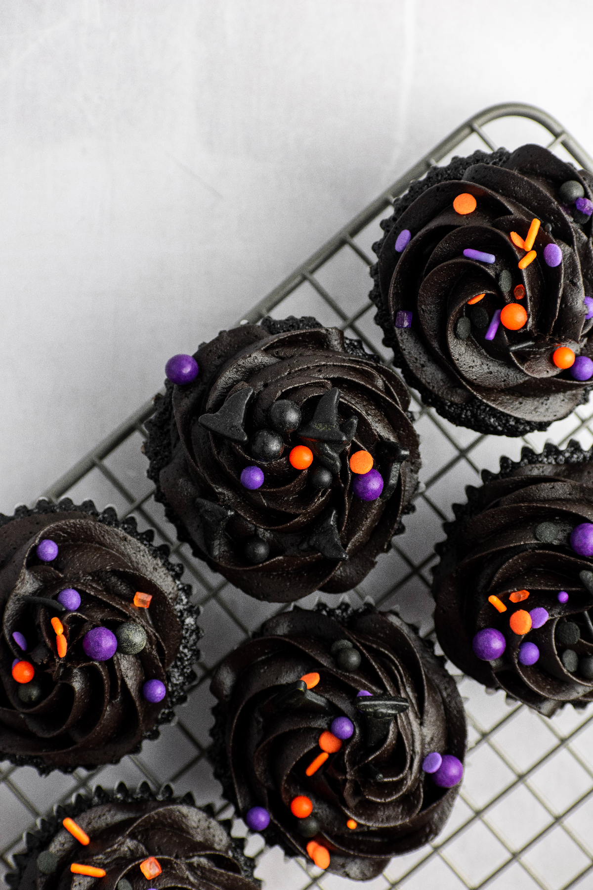 Frosted cupcakes with halloween sprinkles on top.