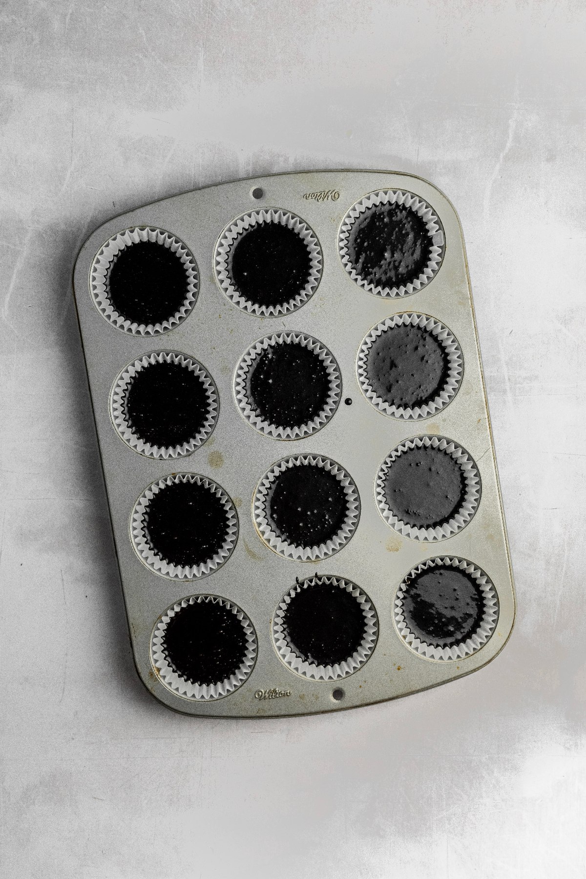 Muffin pan filled with cupcake batter.