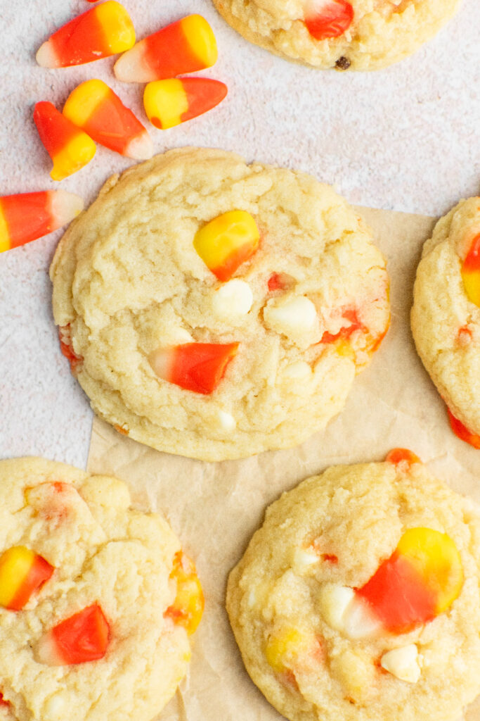 Candy corn scattered around sugar cookies.