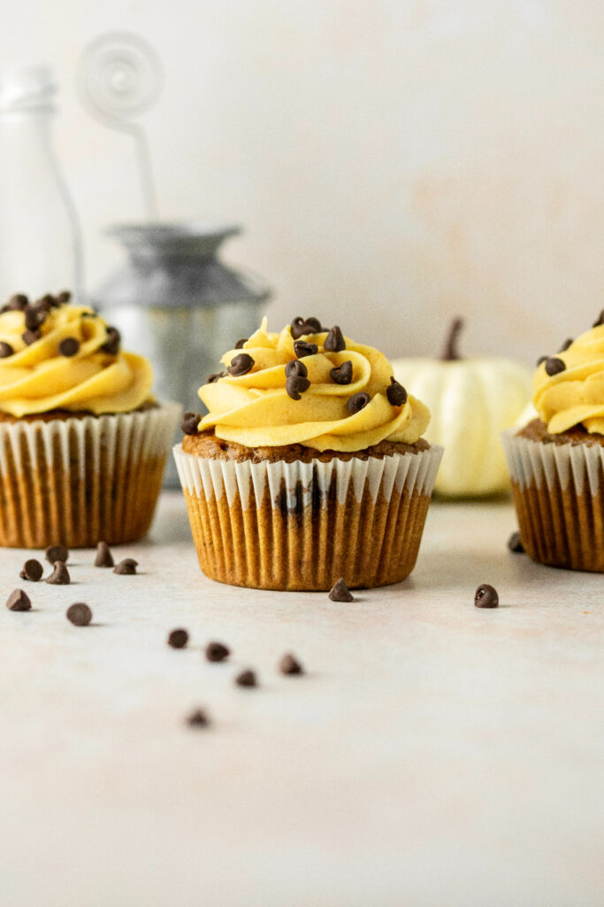 Pumpkin frosted cupcakes with mini chocolate chips every where.