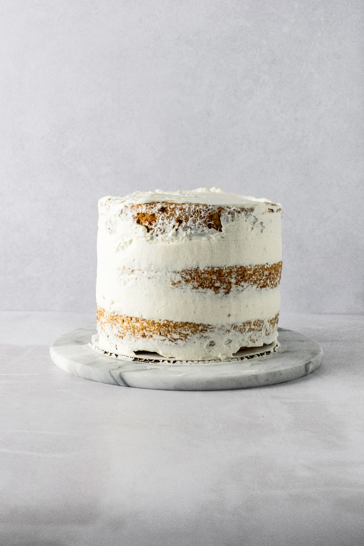 A crumb coat on the outside of a three layer cake.
