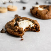 A bite taken out of a chocolate marshmallow cookie.