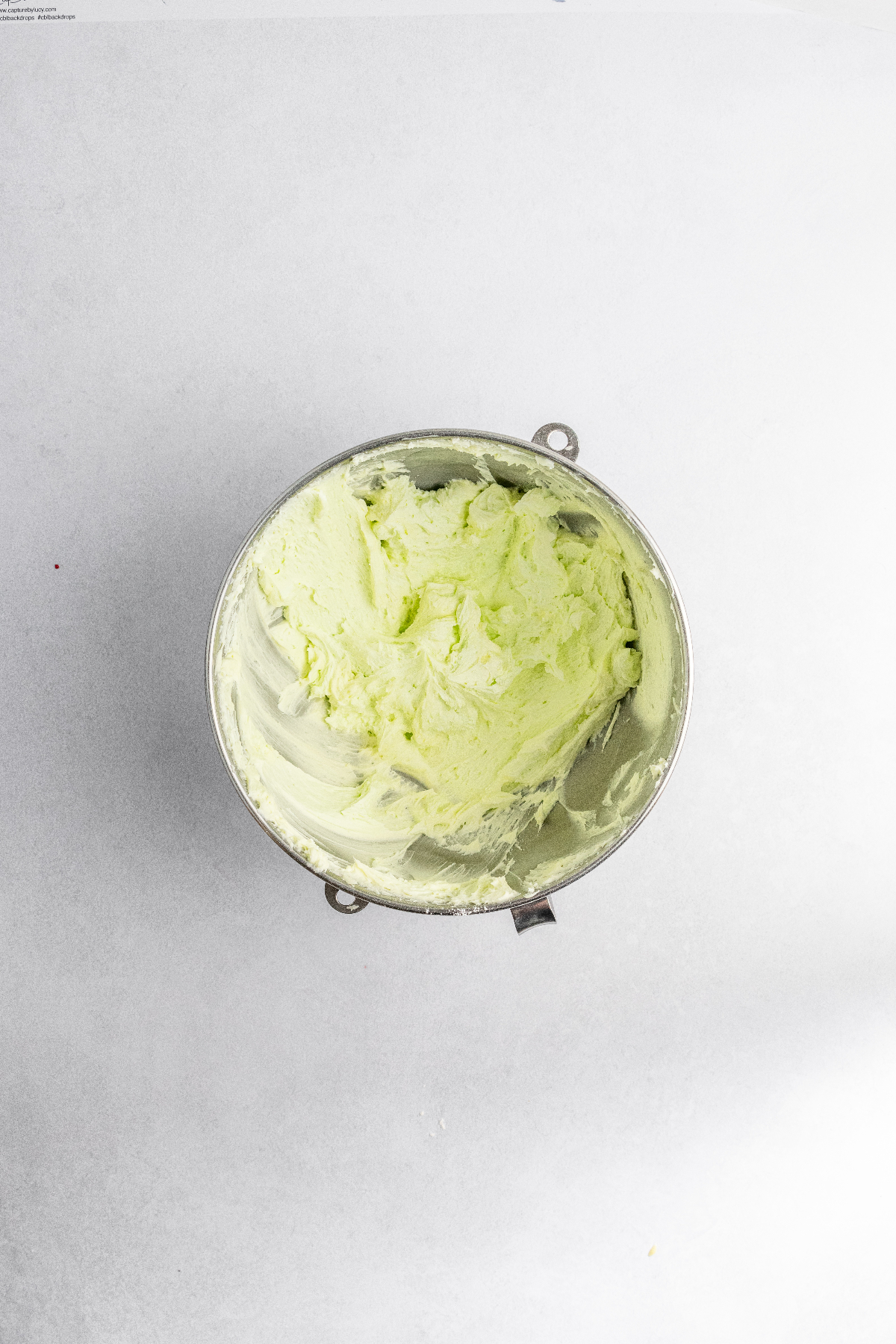 Green mint frosting in stand mixer bowl.