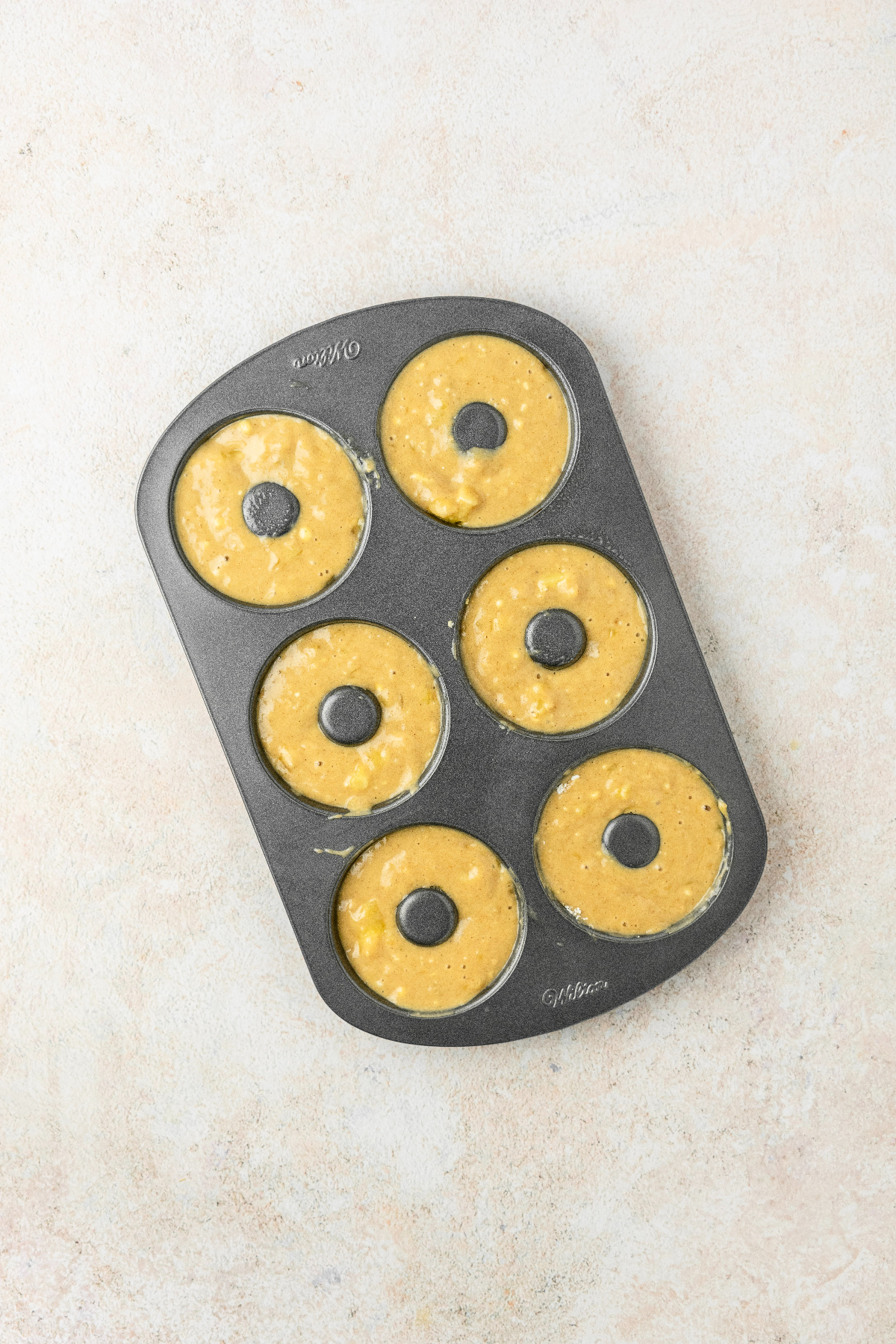 Donut pan filled with batter and ready to bake.