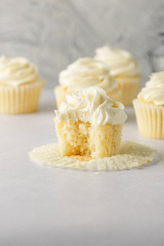 Best vanilla cupcakes with a bite taken out of one of them.