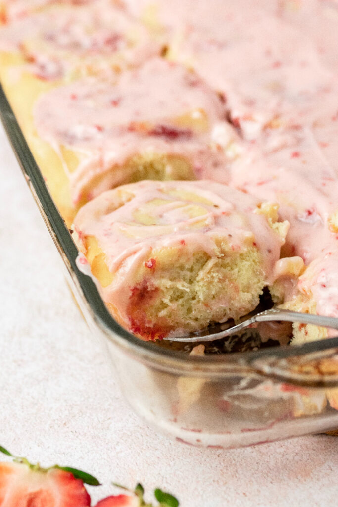 Fluffy strawberry sweet roll with strawberry icing.