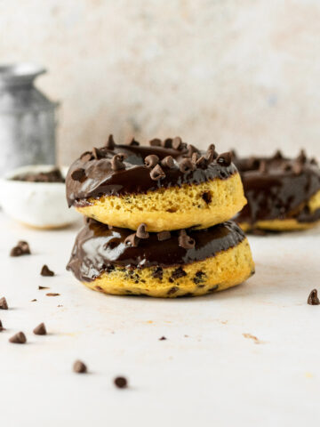 Stacked chocolate chip donuts with mini chocolate chips around them.