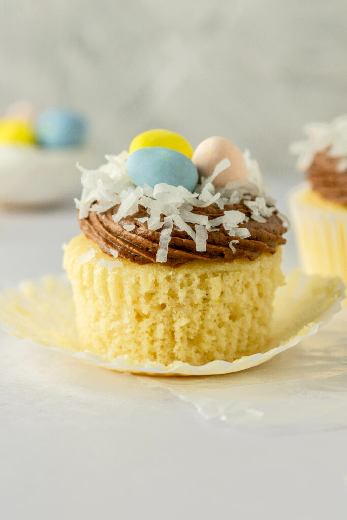 Super moist and fluffy vanilla cupcakes with shredded coconut on top and cadbury mini eggs.