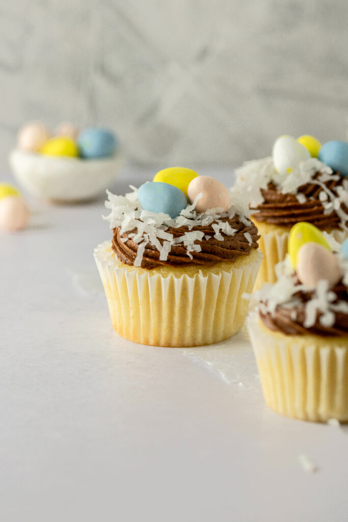 Easter cupcakes with shredded coconut and colored eggs.