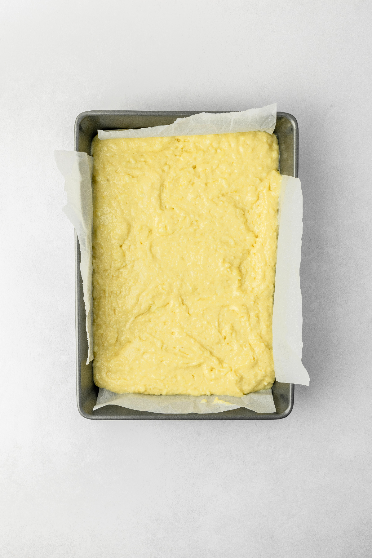 Lemon cake batter in a baking sheet pan.