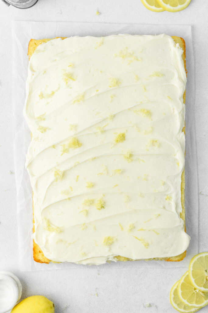 Lemon sheet cake with cream cheese icing and lemon zest on top.
