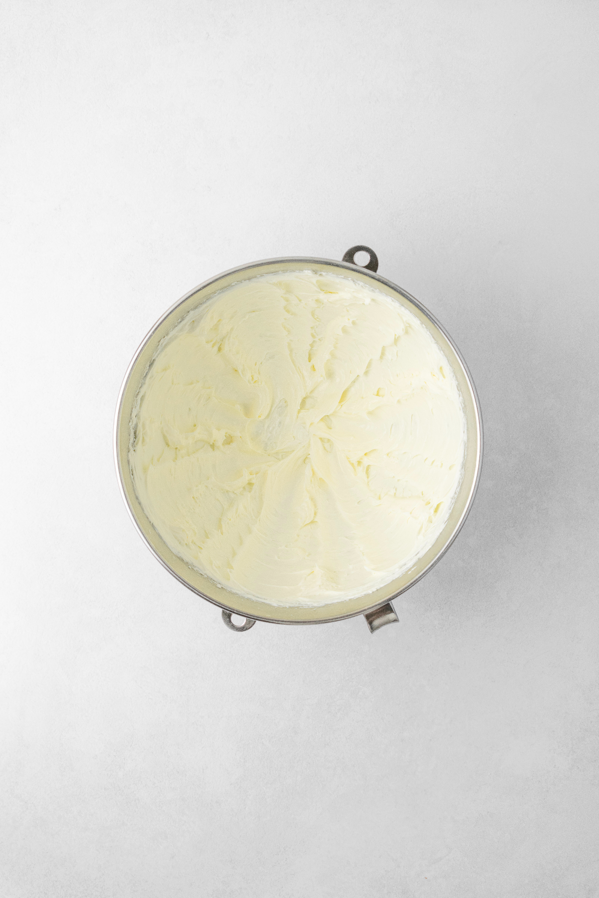 Creamed cream cheese in a stainless steel bowl.