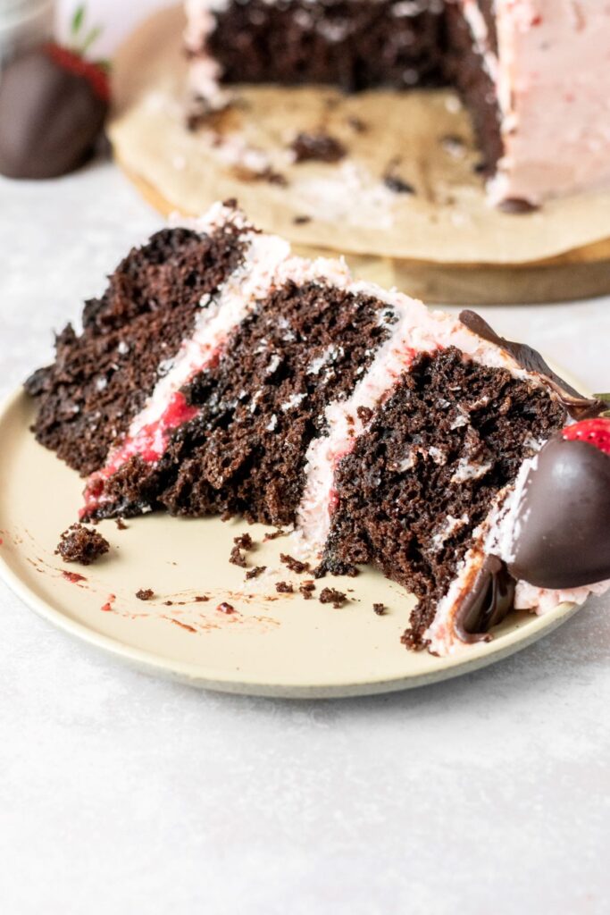 A chocolate strawberry cake slice with a bite taken out of it.