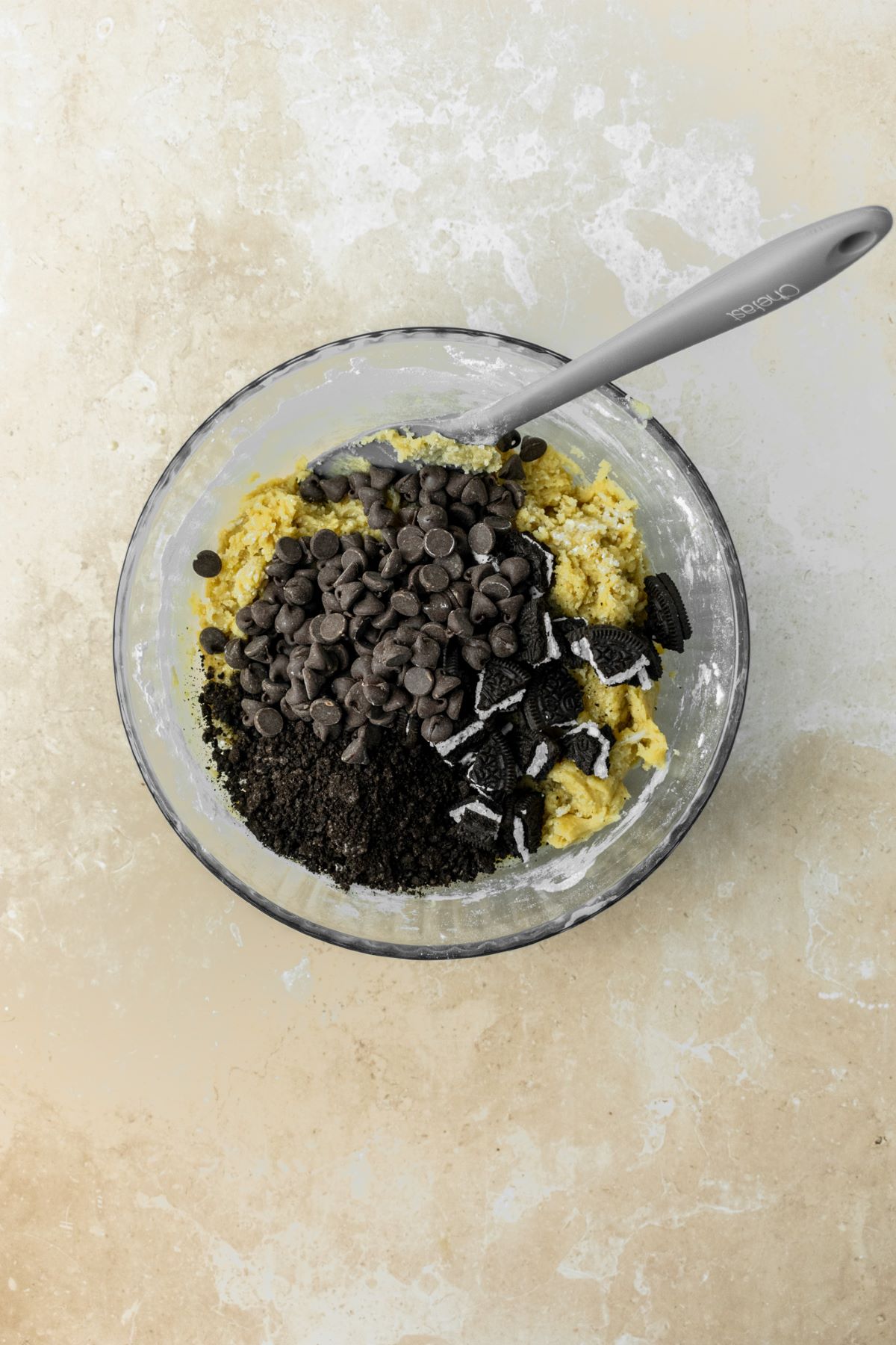 Cookie dough with Oreo crumbs, pieces, and chocolate chips on top.