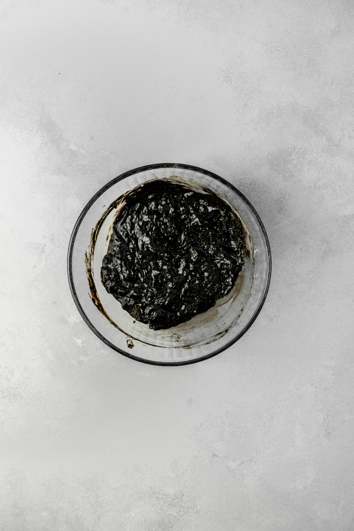 Black oreo donut batter in a glass bowl.